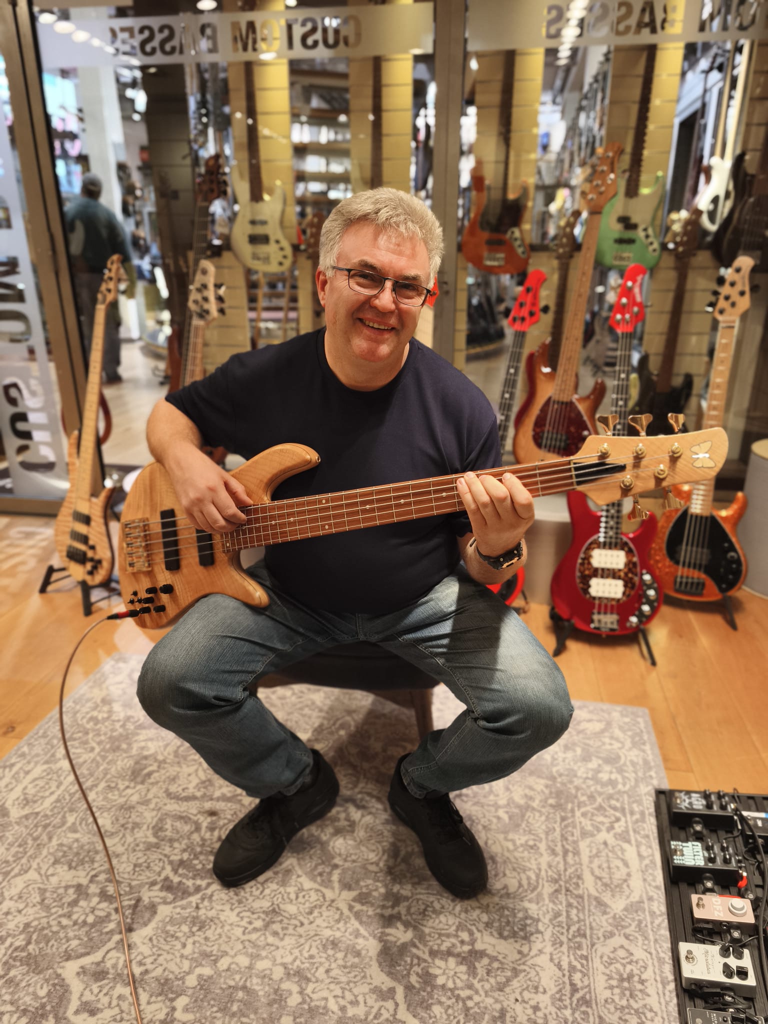 Papa mit einem Bass in einem Musikgeschäft